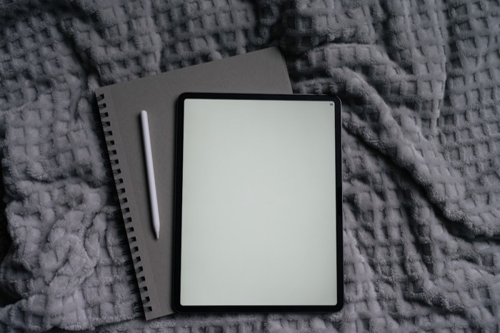 A person writing in a notebook by soft lamplight before bed