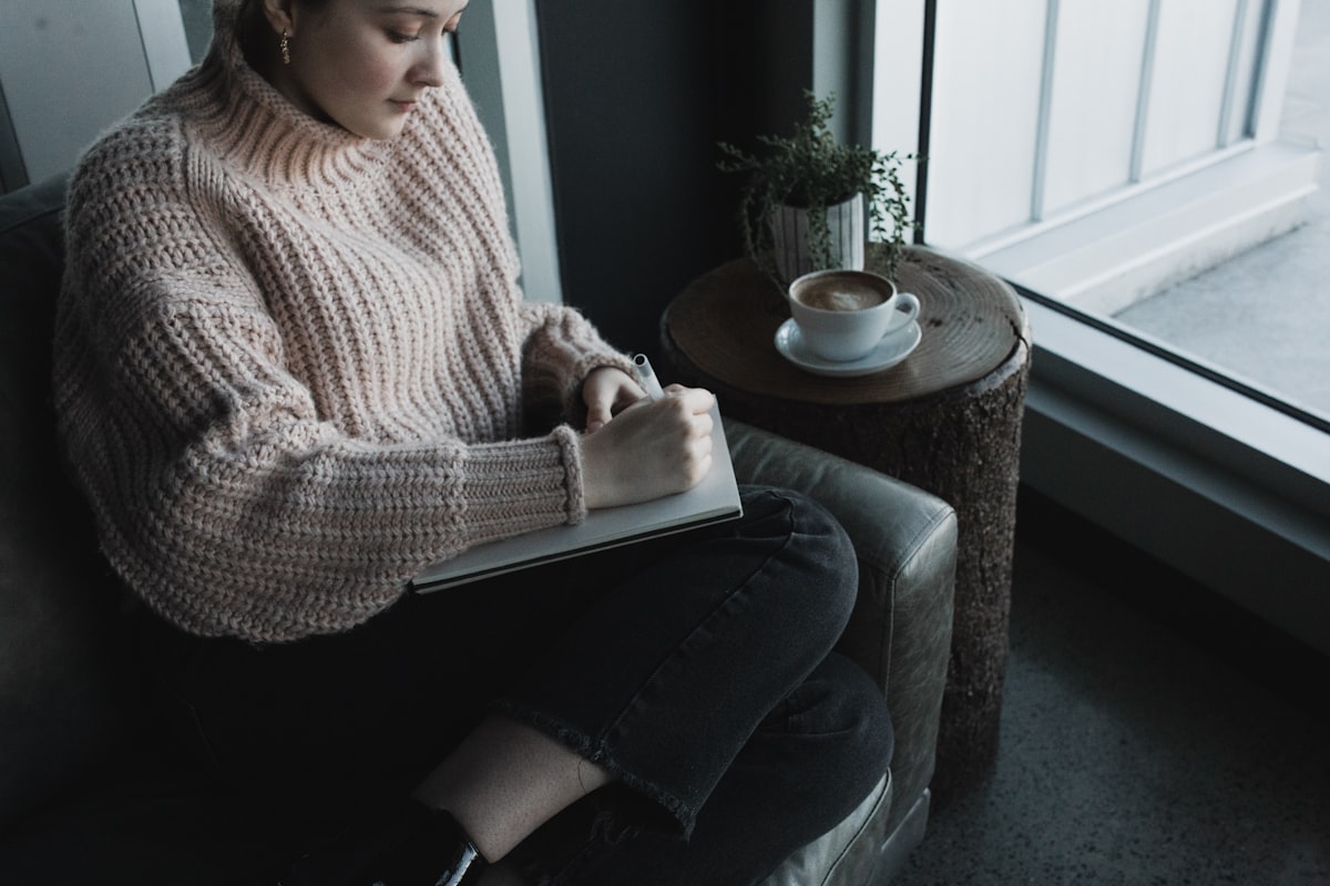 A person sitting alone in a quiet room, reading and reflecting in soft light