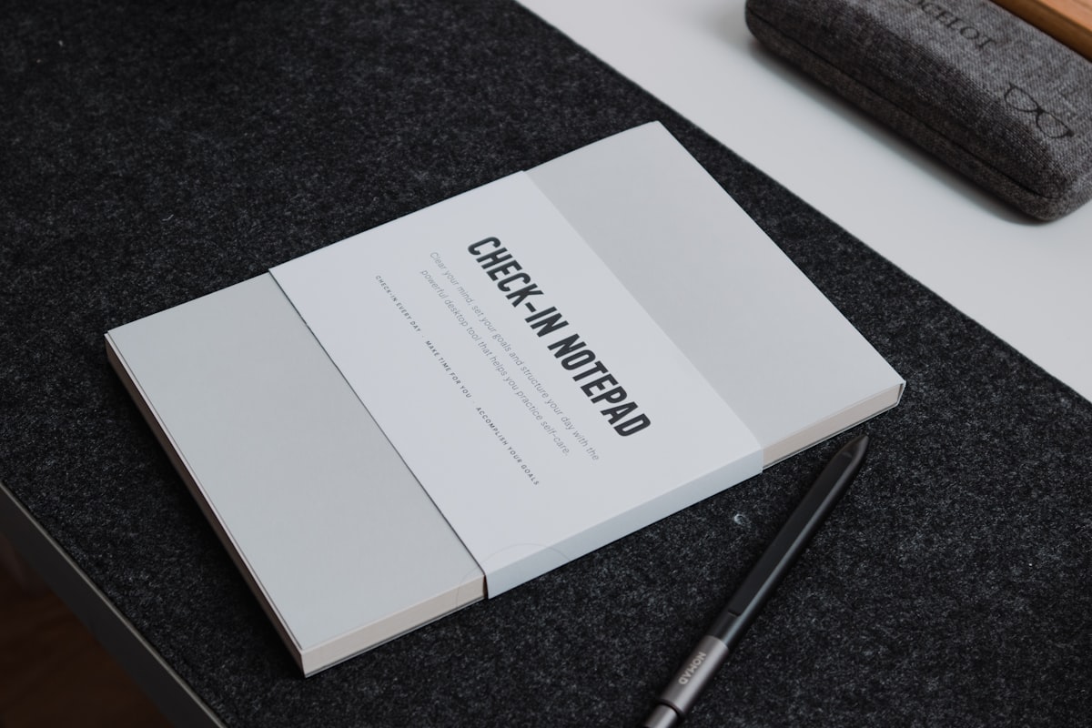 An open notebook with one handwritten sentence on a page, morning light streaming across the desk