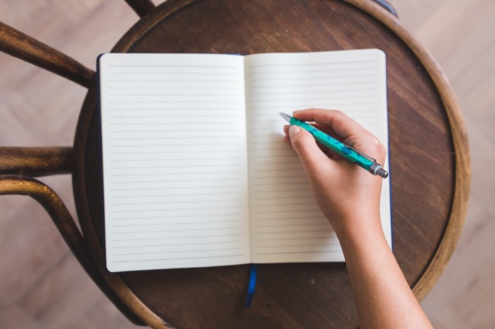 An open notebook with handwritten stream of consciousness writing, pen resting on the page