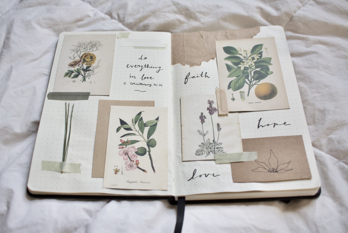 An open scrapbook diary spread with photographs, handwritten notes, and colorful washi tape on a wooden surface